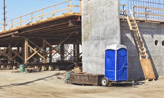 multiple porta potties arranged at a busy work site